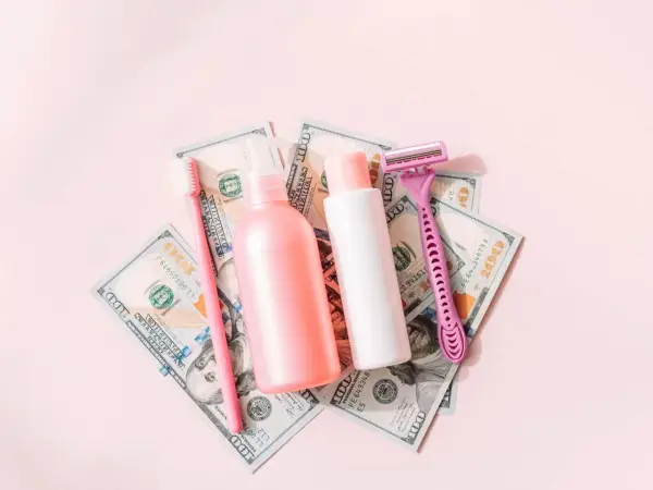 Rosa Rasierer, Zahnbürste und Kosmetikflaschen auf 100-Dollar-Scheinen. Ein Symbol für den "Pink Tax", der Frauen mehr kostet.